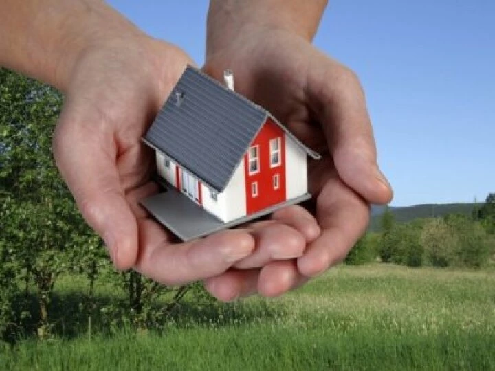 Hands holding a toy house