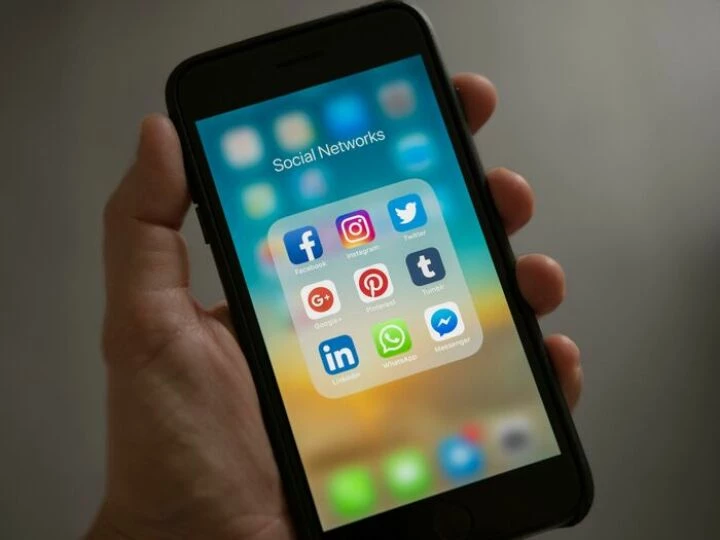 Person Holding Iphone Showing Social Networks Fold