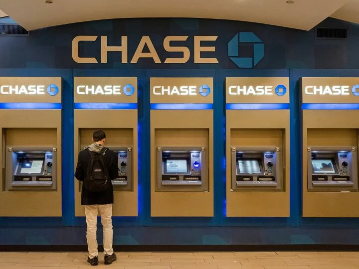 Male customer using Chase ATM machine in an urban indoor setting.