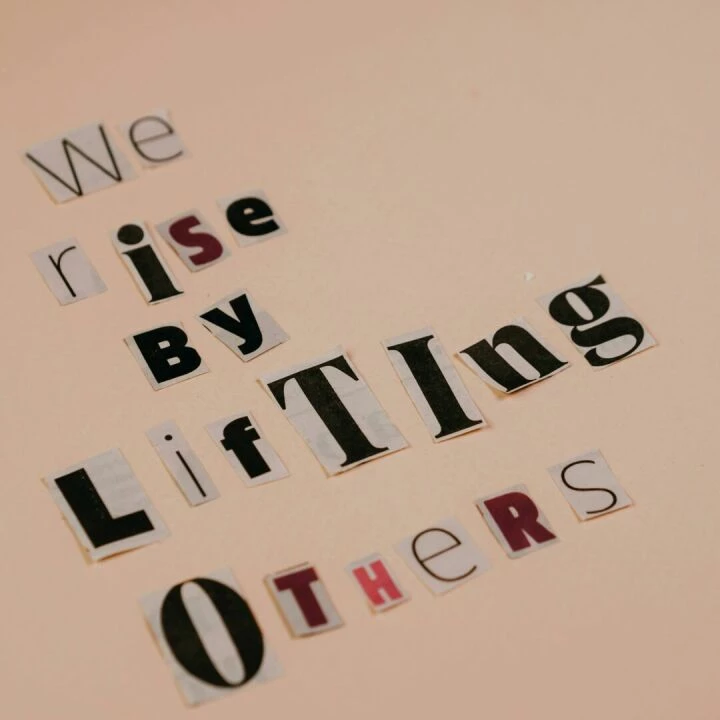Cutout letters forming an inspirational quote on a beige background, encouraging positivity.