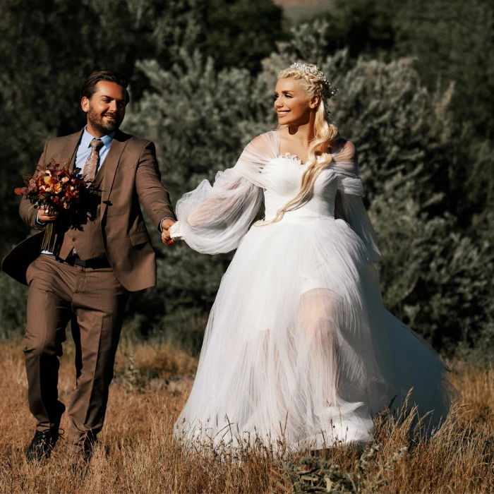 bride and groom walking in field