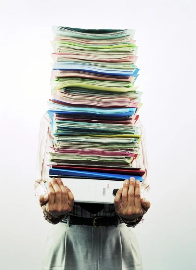 businessman carrying pile of files