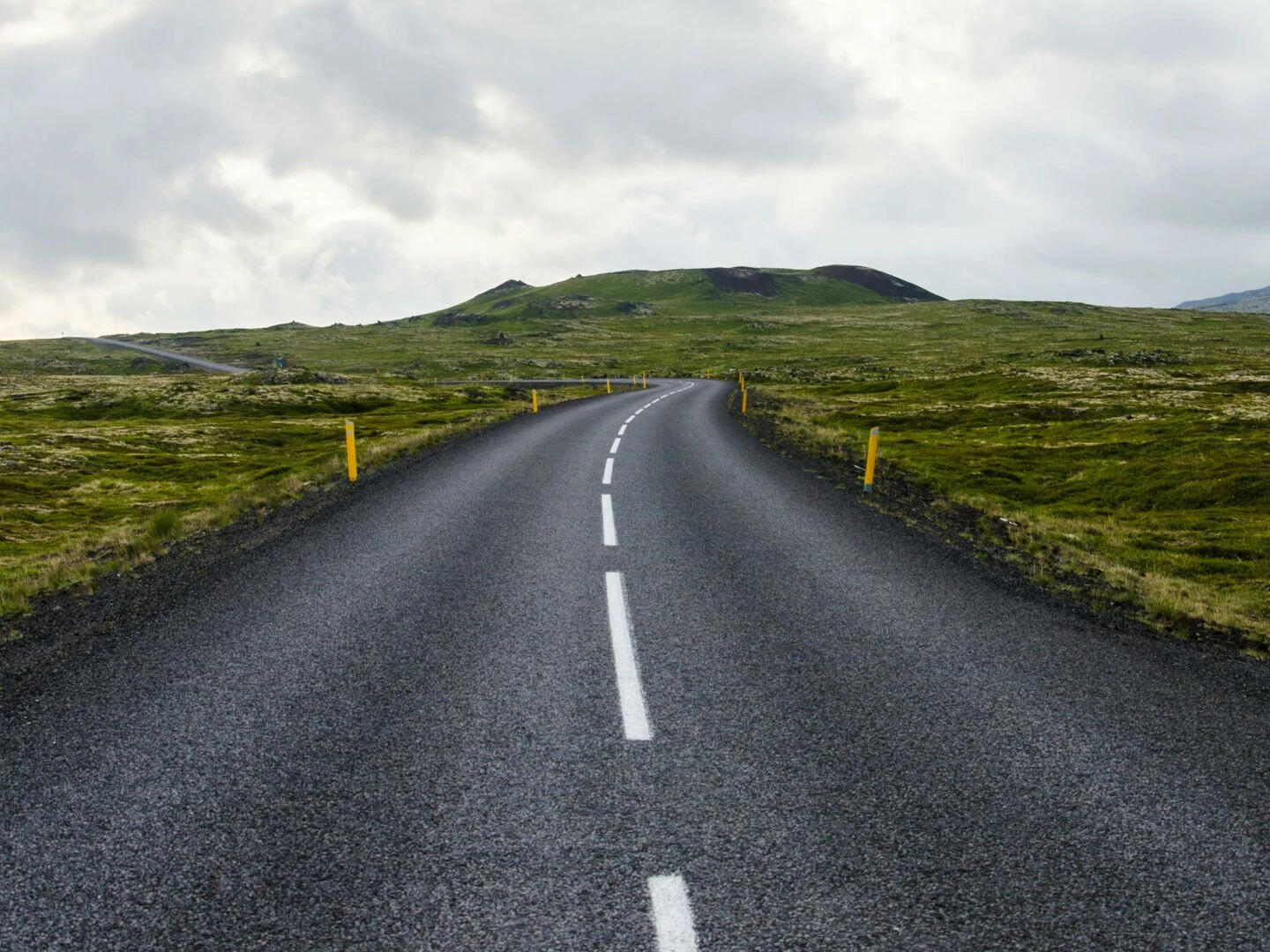 empty road stretches through lush countryside under cloudy skies ideal for travel themes