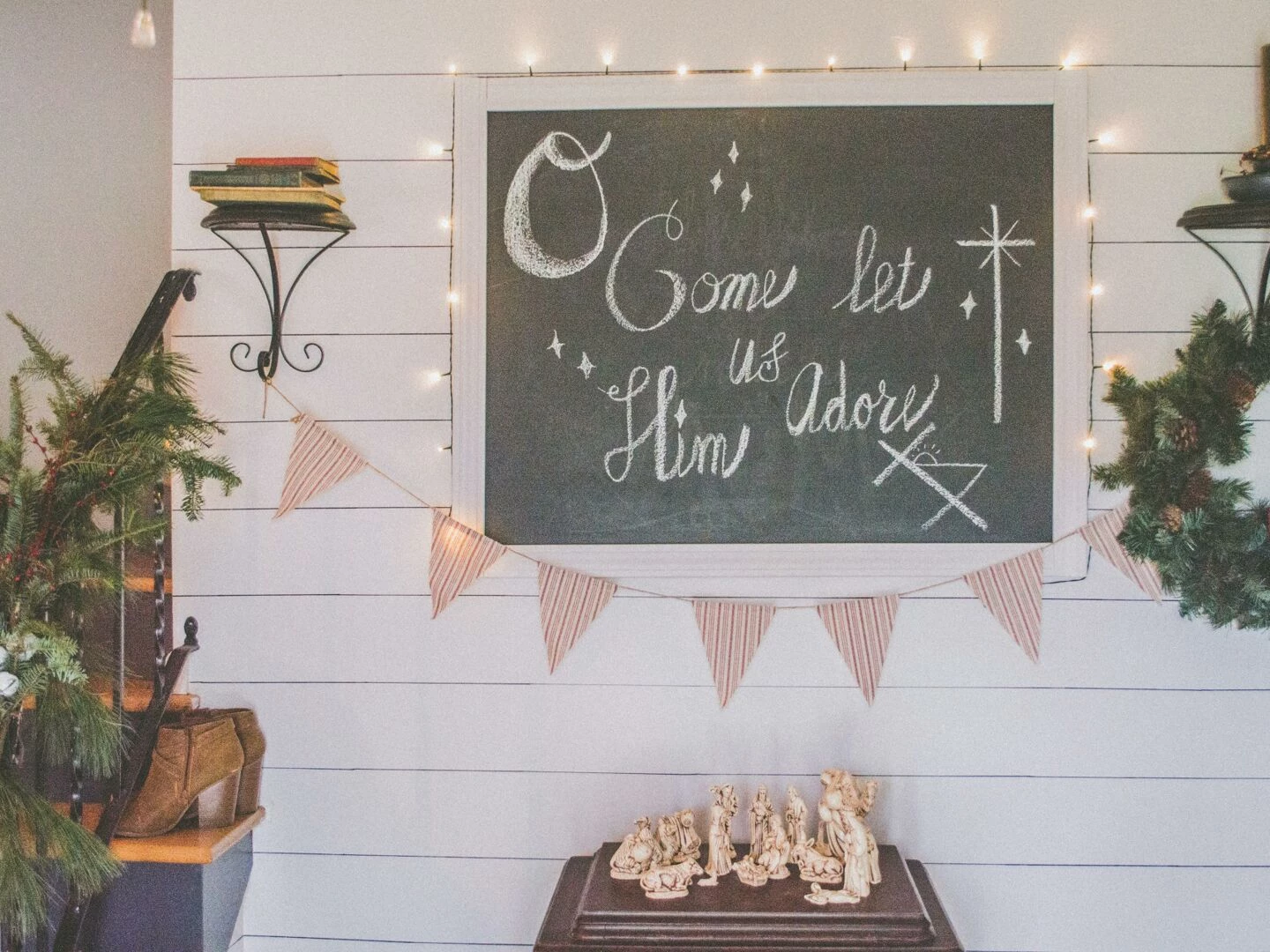 festive christmas setup featuring a chalkboard with holiday message wreath and nativity scene