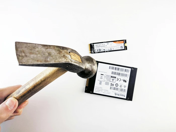 hand with hammer crashing hard drive