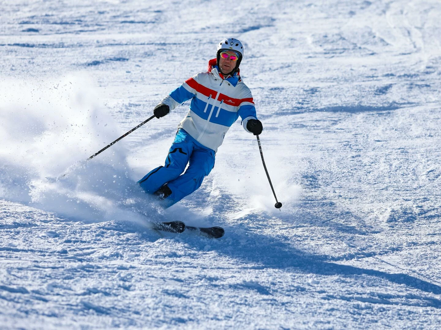man skiing down snowy slope in vorarlberg austria on a sunny winter day